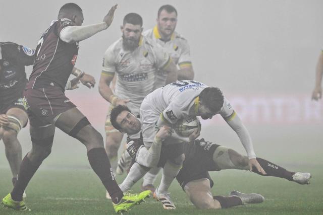 Clermont's French scrum-half Sebastien Bezy (CR) is tackled by Bordeaux-Begles' French fly-half Joseph Carbery (CL) during the French Top14 rugby union match between ASM Clermont Auvergne and Union Bordeaux-Begles (UBB) at the Marcel-Michelin Stadium in Clermont-Ferrand, central France on December 27, 2025. (Photo by JEFF PACHOUD / AFP)