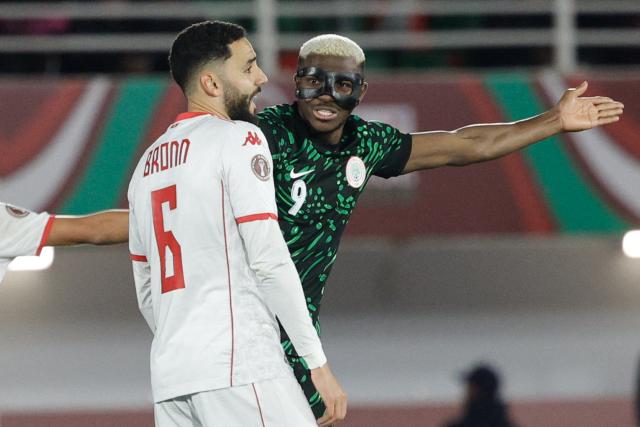 Nigeria's forward #09 Victor Osimhen speaks to Tunisia's defender #06 Dylan Bronn during the Africa Cup of Nations (CAN) Group C football match between Nigeria and Tunisia at Fez Stadium in Fez on December 27, 2025. (Photo by Abdel Majid BZIOUAT / AFP)