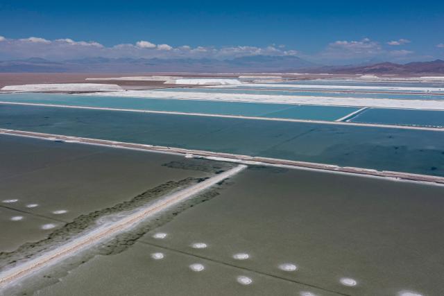 (FILES) Aerial view of brine ponds and processing areas of the lithium mine of the Chilean company SQM (Sociedad Quimica Minera) in the Atacama Desert, Calama, Chile, on September 12, 2022. On December 27, 2025, Chilean state-owned company Codelco, the world's leading copper producer, and private mining company SQM announced the creation of a giant company for lithium mining in Chile, the country with the largest reserves of this metal, which is key to the energy transition. (Photo by Martin BERNETTI / AFP)