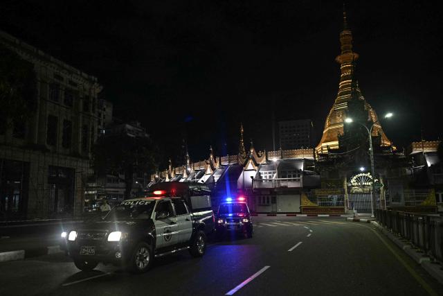Police officers patrol in front of the Sule Pagoda near a polling station during the first phase of Myanmar's general election in Yangon on December 28, 2025. Voting begins in Myanmar's heavily restricted polls, with the ruling junta touting the exercise as a return to democracy five years after it ousted the last elected government, triggering civil war. (Photo by Lillian SUWANRUMPHA / AFP)