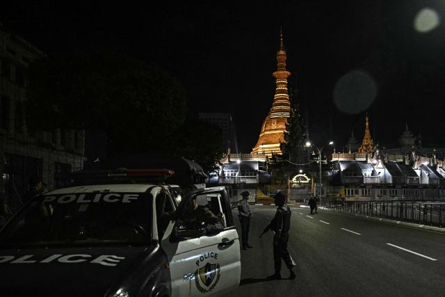Police officers patrol in front of the Sule Pagoda near a polling station during the first phase of Myanmar's general election in Yangon on December 28, 2025. Voting begins in Myanmar's heavily restricted polls, with the ruling junta touting the exercise as a return to democracy five years after it ousted the last elected government, triggering civil war. (Photo by Lillian SUWANRUMPHA / AFP)