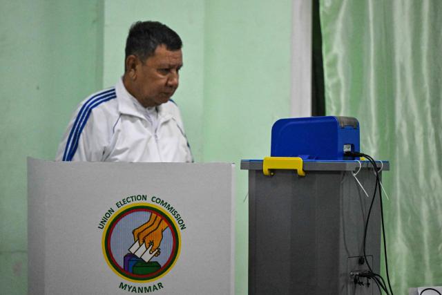 A man uses an electronic voting booth at a polling station during the first phase of Myanmar's general election in Yangon on December 28, 2025. Voting begins in Myanmar's heavily restricted polls, with the ruling junta touting the exercise as a return to democracy five years after it ousted the last elected government, triggering civil war. (Photo by NHAC NGUYEN / AFP)