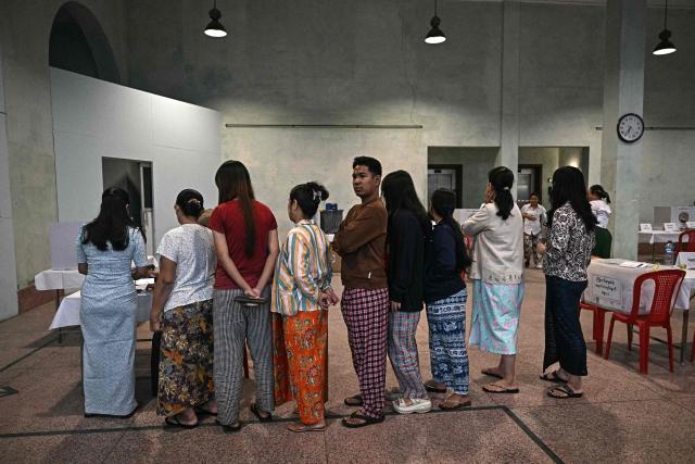 TOPSHOT - Voters line up inside a polling station during the first phase of Myanmar's general election in Yangon on December 28, 2025. Polling opened in Myanmar's heavily restricted junta-run elections, beginning a month-long vote democracy watchdogs describe as a rebranding of military rule. (Photo by Lillian SUWANRUMPHA / AFP)