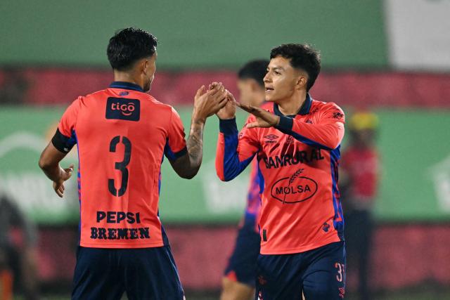 Municipal's midlfielder #31 Cesar Calderon (R) celebrates with teammate Costa Rican defender #03 Jose Mena scoring his team's first goal during the second leg of the Guatemalan Apertura tournament final at El Trebol Stadium in Guatemala City on December 27, 2025. (Photo by JOHAN ORDONEZ / AFP)
