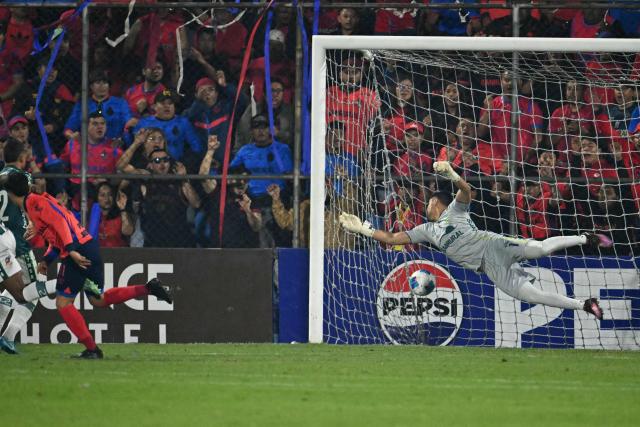 Municipal's midlfielder #31 Cesar Calderon (L) heads the ball and scores his team's first goal against Antigua's goalkeeper #01 Luis Moran during the second leg of the Guatemalan Apertura tournament final between Municipal and Antigua at El Trebol Stadium in Guatemala City on December 27, 2025. (Photo by JOHAN ORDONEZ / AFP)