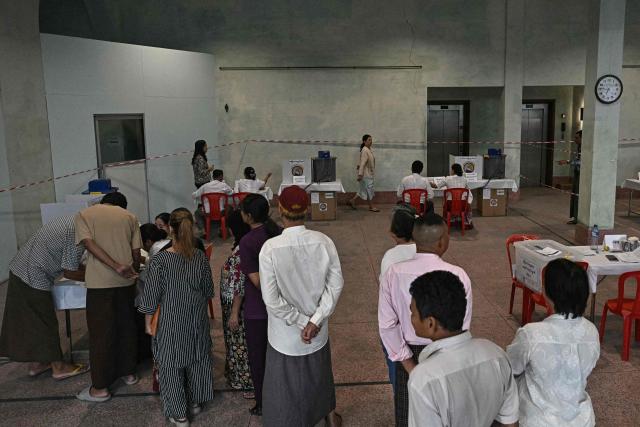 Voters line up inside a polling station during the first phase of Myanmar's general election in Yangon on December 28, 2025. Polling opened in Myanmar's heavily restricted junta-run elections, beginning a month-long vote democracy watchdogs describe as a rebranding of military rule. (Photo by Lillian SUWANRUMPHA / AFP)