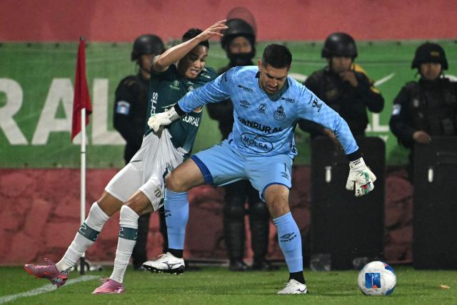 Antigua´s midfielder #18 Oscar Santis and Municipal's goalkeeper #01 Braulio Linares fight for the ball during the Guatemalan Apertura tournament final second-leg football match between Municipal and Antigua at El Trebol Stadium in Guatemala City on December 27, 2025. (Photo by JOHAN ORDONEZ / AFP)