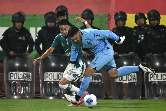 Antigua´s midfielder #18 Oscar Santis and Municipal's goalkeeper #01 Braulio Linares fight for the ball during the Guatemalan Apertura tournament final second-leg football match between Municipal and Antigua at El Trebol Stadium in Guatemala City on December 27, 2025. (Photo by JOHAN ORDONEZ / AFP)