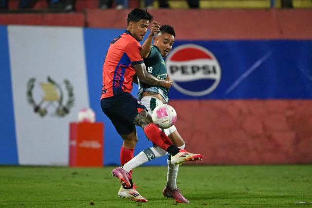 Municipal's Costa Rican defender #03 Jose Mena and Antigua´s midfielder #18 Oscar Santis fight for the ball during the Guatemalan Apertura tournament final second-leg football match between Municipal and Antigua at El Trebol Stadium in Guatemala City on December 27, 2025. (Photo by JOHAN ORDONEZ / AFP)