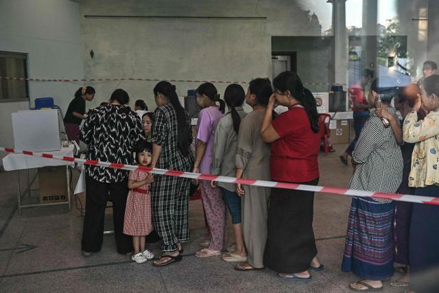 People line up to vote inside a polling station during the first phase of Myanmar's general election in Yangon on December 28, 2025. Polling opened in Myanmar's heavily restricted junta-run elections, beginning a month-long vote democracy watchdogs describe as a rebranding of military rule. (Photo by Lillian SUWANRUMPHA / AFP)