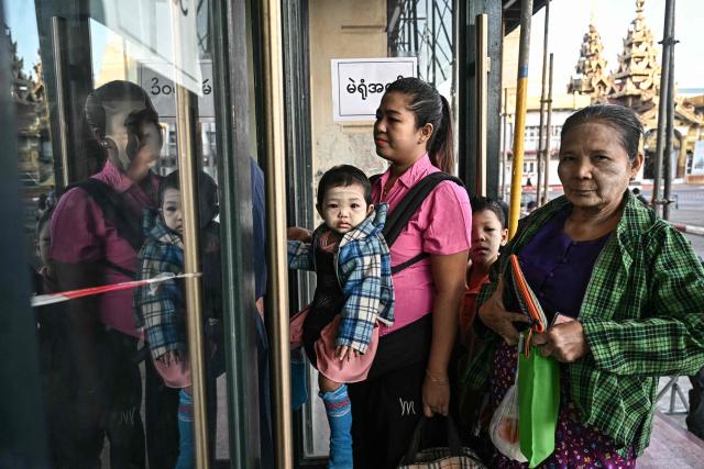 People line up to vote at a polling station during the first phase of Myanmar's general election in Yangon on December 28, 2025. Polling opened in Myanmar's heavily restricted junta-run elections, beginning a month-long vote democracy watchdogs describe as a rebranding of military rule. (Photo by Lillian SUWANRUMPHA / AFP)