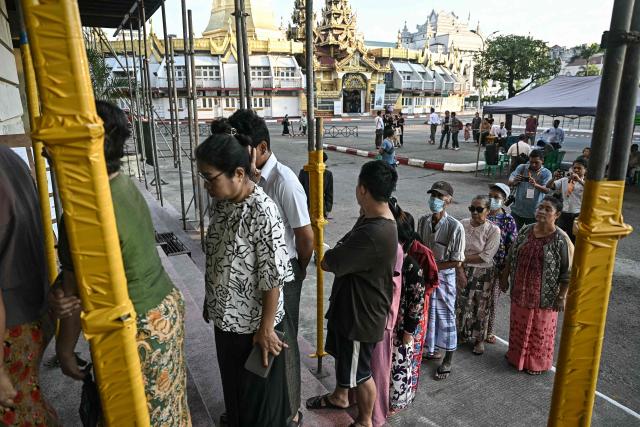 People line up to vote at a polling station during the first phase of Myanmar's general election in Yangon on December 28, 2025. Polling opened in Myanmar's heavily restricted junta-run elections, beginning a month-long vote democracy watchdogs describe as a rebranding of military rule. (Photo by Lillian SUWANRUMPHA / AFP)