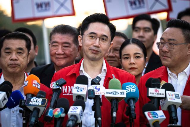 Pheu Thai Party candidate Yodchanan Wongsawat (C) speaks to the press as he arrives for the first day of the constituencies candidates registration for the upcoming general election, in Bangkok on December 28, 2025. (Photo by Chanakarn Laosarakham / AFP)
