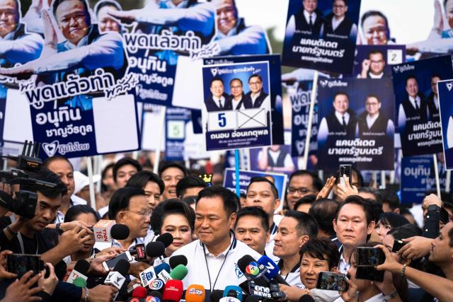 Thailand's Prime Minister and Bhumjaithai Party candidate Anutin Charnvirakul (C) arrives for the first day of the constituencies candidates registration for the upcoming general election, in Bangkok on December 28, 2025. (Photo by Chanakarn Laosarakham / AFP)