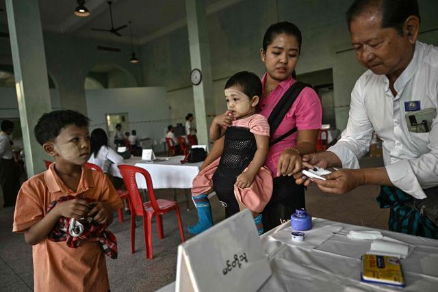 TOPSHOT - A woman has her finger inked after voting at a polling station during the first phase of Myanmar's general election in Yangon on December 28, 2025. Polling opened in Myanmar's heavily restricted junta-run elections, beginning a month-long vote democracy watchdogs describe as a rebranding of military rule. (Photo by Lillian SUWANRUMPHA / AFP)