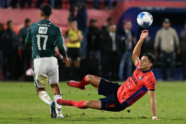 Antigua´s defender #17 Oscar Castellanos and Municipal's forward #09 Jose Martinez fight for the ball during the Guatemalan Apertura tournament final second-leg football match between Municipal and Antigua at El Trebol Stadium in Guatemala City on December 27, 2025. (Photo by JOHAN ORDONEZ / AFP)