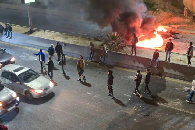 Protesters block a street with burning tires during a demonstration against Prime Minister Abdulhamid Dbeibah’s internationally recognised Government of National Unity (GNU) in Tripoli on December 27, 2025. (Photo by POOL / AFP)