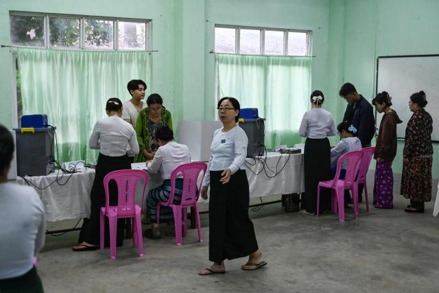 People line up to vote inside a polling station during the first phase of Myanmar's general election in Yangon on December 28, 2025. Polling opened in Myanmar's heavily restricted junta-run elections, beginning a month-long vote democracy watchdogs describe as a rebranding of military rule. (Photo by NHAC NGUYEN / AFP)