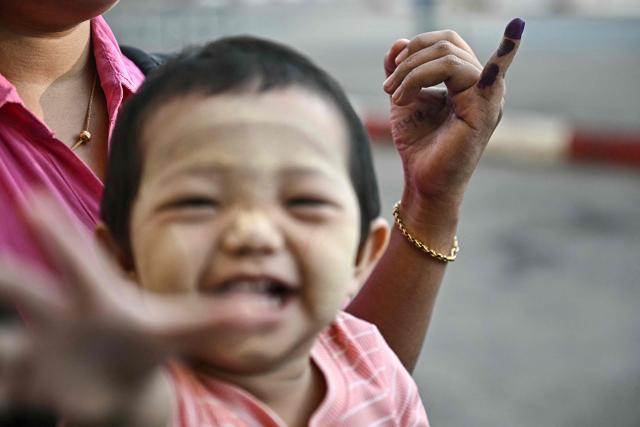 A woman shows her inked finger after voting at a polling station during the first phase of Myanmar's general election in Yangon on December 28, 2025. Polling opened in Myanmar's heavily restricted junta-run elections, beginning a month-long vote democracy watchdogs describe as a rebranding of military rule. (Photo by Lillian SUWANRUMPHA / AFP)