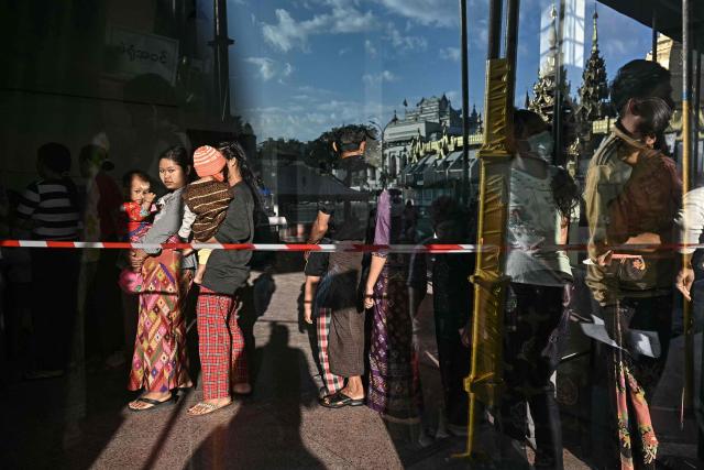 People line up to vote at a polling station during the first phase of Myanmar's general election in Yangon on December 28, 2025. Polling opened in Myanmar's heavily restricted junta-run elections, beginning a month-long vote democracy watchdogs describe as a rebranding of military rule. (Photo by Lillian SUWANRUMPHA / AFP)