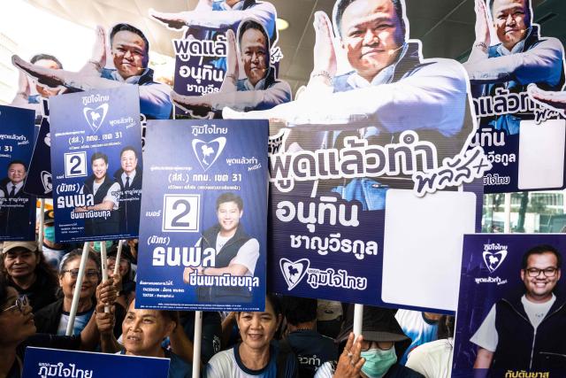 Supporters pose with placards to support Thai prime minister and Bhumjaithai Party leader Anutin Charnvirakul during the first day of the constituencies candidates registration for the upcoming general election, in Bangkok on December 28, 2025. (Photo by Chanakarn Laosarakham / AFP)