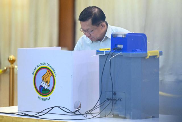 Myanmar's junta chief Min Aung Hlaing uses an electronic voting booth at a polling station during the first phase of Myanmar's general election in Naypyidaw on December 28, 2025. (Photo by Sai Aung MAIN / AFP)