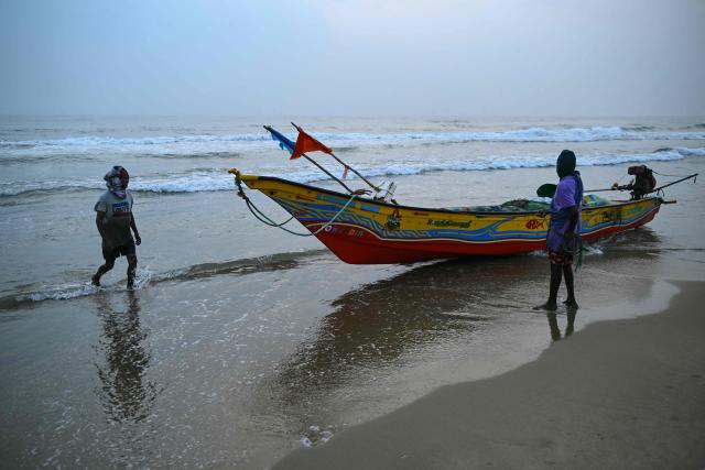 Fishermen return after their early morning catch at the Marina beach in Chennai on December 28, 2025. (Photo by R. Satish BABU / AFP)
