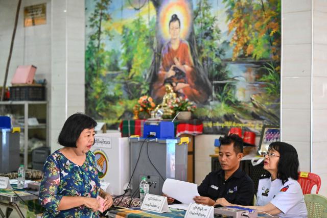 A woman arrives to vote at a polling station during the first phase of Myanmar's general election in Yangon on December 28, 2025. (Photo by NHAC NGUYEN / AFP)