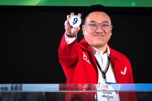 Pheu Thai Party leader Julapun Amornvivat shows the number of his party's draw during the constituencies candidates registration for the upcoming general election, in Bangkok on December 28, 2025. (Photo by Chanakarn Laosarakham / AFP)
