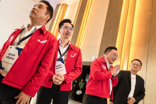Pheu Thai Party candidate Yodchanan Wongsawat (C) and 
party leader Julapun Amornvivat (2nd R) leave after the constituencies candidates registration for the upcoming general election, in Bangkok on December 28, 2025. (Photo by Chanakarn Laosarakham / AFP)
