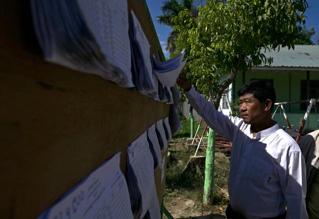 A voter looks for his name on the registry at a polling station during the first phase of Myanmar's general election in Naypyidaw on December 28, 2025. (Photo by Sai Aung MAIN / AFP)