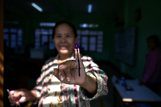 TOPSHOT - A woman shows her inked finger after casting her vote at a polling station during the first phase of Myanmar's general election in Naypyidaw on December 28, 2025. (Photo by Sai Aung MAIN / AFP)