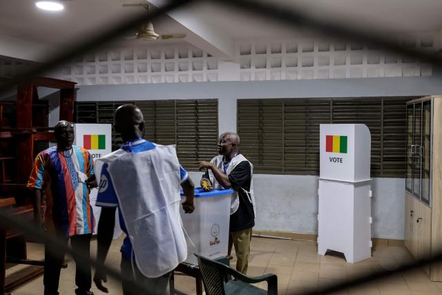 Official of the General Directorate of Elections (DGE) set up a ballot box at a polling station in Conakry on December 28, 2025 before polls open during Guinea's presidential election. (Photo by Patrick MEINHARDT / AFP)