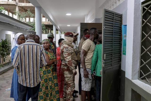 A member of Guinea's Special Forces Unit (C) queues with other voters at a polling station in Conakry on December 28, 2025 during Guinea's presidential election. (Photo by Patrick MEINHARDT / AFP)