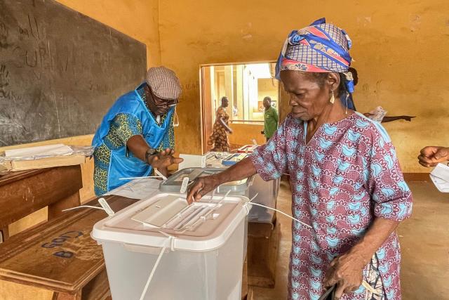 A voter casts her ballot at a polling station in Bangui on December 28, 2025 during Central African Republic's presidential election. (Photo by Annela NIAMOLO / AFP)
