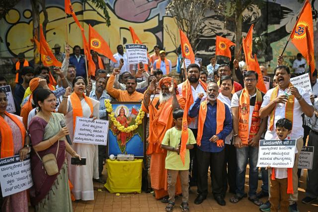 Hindu Rashtra Coordination Committee supporters hold saffron religious flags and shout slogans next to a portrait of Goddess Durga during a protest to condemn Bangladesh's alleged atrocities against Hindus, at the Freedom Park in Bengaluru on December 28, 2025. On December 18, angry mobs in the majority Muslim nation of Bangladesh's capital of Dhaka attacked the offices of Prothom Alo and the Daily Star, torching parts of the buildings and vandalising the premises of the two publications caught up in surging anti-India sentiment in the wake of popular student leader Sharif Osman Hadi's death. The violence also saw Hindu garment worker Dipu Chandra Das killed following allegations of blasphemy. (Photo by Idrees MOHAMMED / AFP)