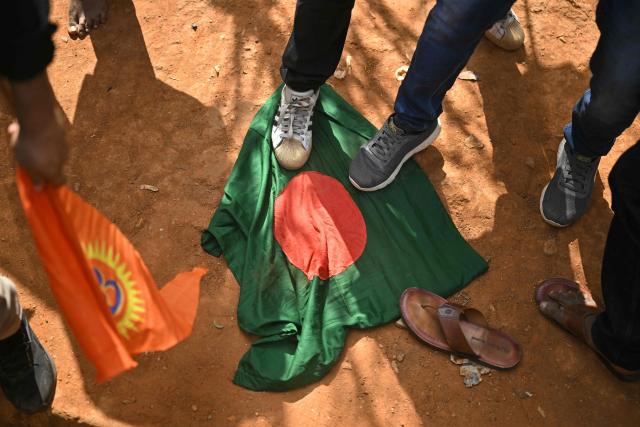 Hindu Rashtra Coordination Committee supporters step on Bangladesh's national flag to protest alleged atrocities against Hindus, at the Freedom Park in Bengaluru on December 28, 2025. Angry mobs in Dhaka, capital of majority Muslim nation Bangladesh attacked the offices of Prothom Alo and the Daily Star on December 18, torching parts of the buildings and vandalising the premises of the two publications caught up in surging anti-India sentiment in the wake of popular student leader Sharif Osman Hadi's death. The violence also saw Hindu garment worker Dipu Chandra Das killed following allegations of blasphemy. (Photo by Idrees MOHAMMED / AFP)