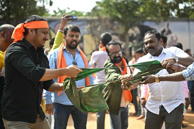 Hindu Rashtra Coordination Committee supporters tear Bangladesh's national flag to protest alleged atrocities against Hindus, at the Freedom Park in Bengaluru on December 28, 2025. Angry mobs in Dhaka, capital of majority Muslim nation Bangladesh attacked the offices of Prothom Alo and the Daily Star on December 18, torching parts of the buildings and vandalising the premises of the two publications caught up in surging anti-India sentiment in the wake of popular student leader Sharif Osman Hadi's death. The violence also saw Hindu garment worker Dipu Chandra Das killed following allegations of blasphemy. (Photo by Idrees MOHAMMED / AFP)