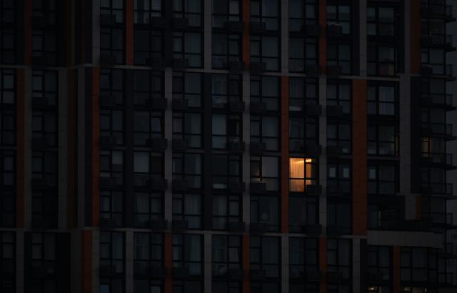 This photograph shows a single lighted window in a multy-storey residential building during a power outage in Kyiv on December 27, 2025, following Russian missile and drone attacks on Ukrainian energy infrastructure amid the Russian invasion of Ukraine. (Photo by Sergei SUPINSKY / AFP)