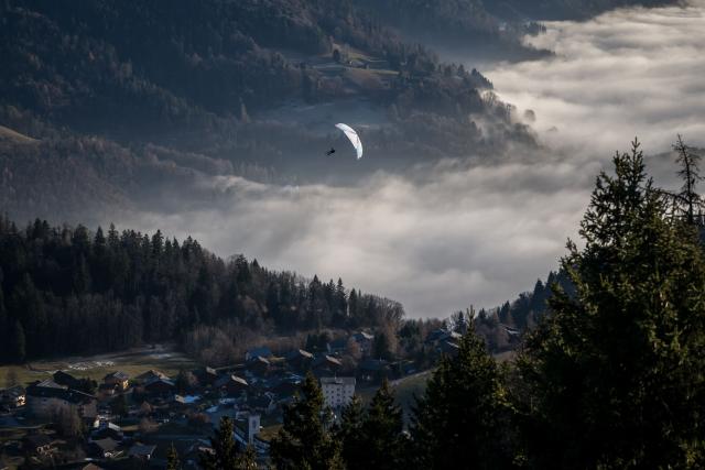 A paraglider soars above a sea of fog over the low-altitude resort of Leysin, western Switzerland on December 27, 2025. (Photo by Fabrice COFFRINI / AFP)