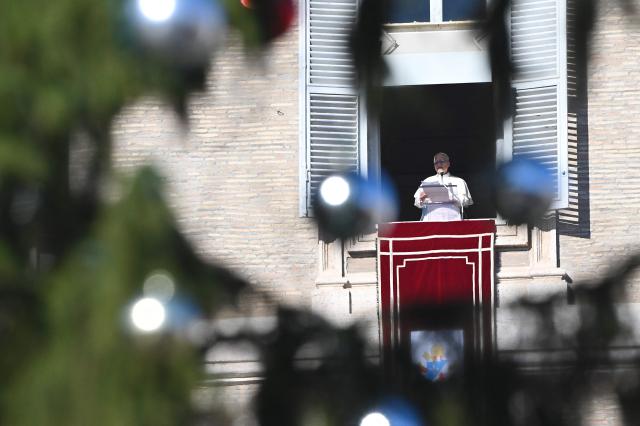 Pope Leo XIV delivers his speech to the crowd from the window of the apostolic palace overlooking St. Peter's square during the Angelus prayer in The Vatican on December 28, 2025. (Photo by Andreas SOLARO / AFP)