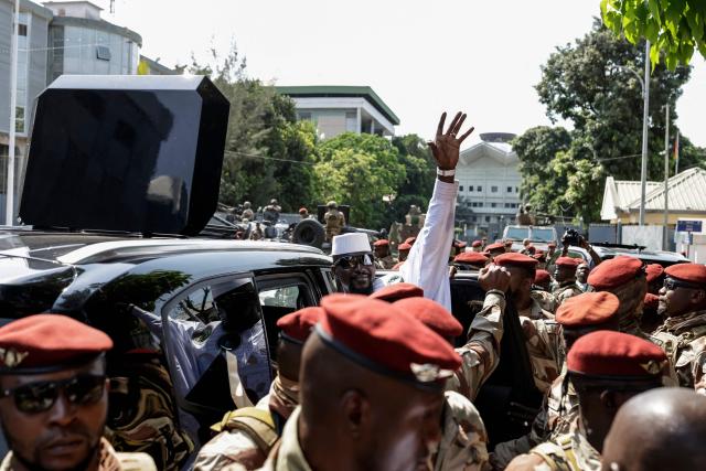 Guinea President and presidential candidate Mamady Doumbouya (C) gestures after casting his ballot at a polling station in Conakry on December 28, 2025 during Guinea's presidential election. (Photo by Patrick MEINHARDT / AFP)