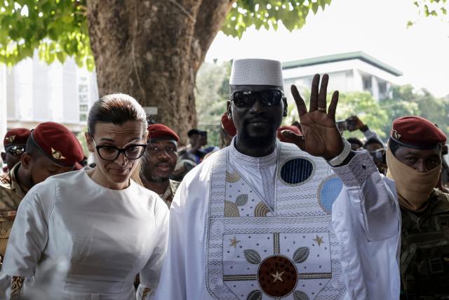 Guinea President and presidential candidate Mamady Doumbouya (CR) and his wife Lauriane Doumbouya (CL) arrive to vote at a polling station in Conakry on December 28, 2025 during Guinea's presidential election. (Photo by Patrick MEINHARDT / AFP)
