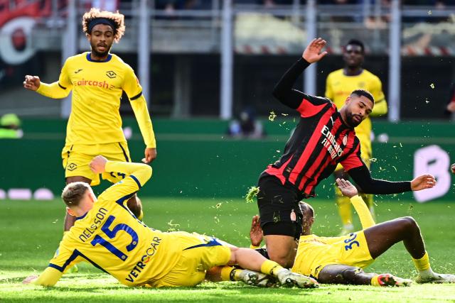 Hellas Verona's Danish defender #15 Victor Nelsson (L) and AC Milan's English midfielder #08 Ruben Loftus-Cheek (R) fight for the ball during the Italian Serie A football match between AC Milan and Hellas Verona at the San Siro stadium in Milan, northern Italy, on December 28, 2025. (Photo by Piero CRUCIATTI / AFP)