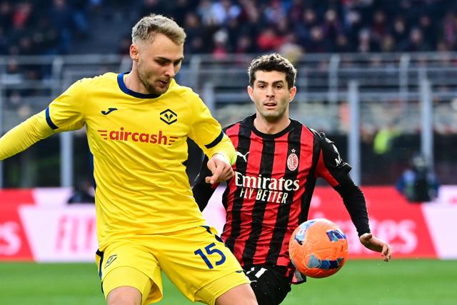 Hellas Verona's Danish defender #15 Victor Nelsson (L) and AC Milan's US forward #11 Christian Pulisic fight for the ball during the Italian Serie A football match between AC Milan and Hellas Verona at the San Siro stadium in Milan, northern Italy, on December 28, 2025. (Photo by Piero CRUCIATTI / AFP)