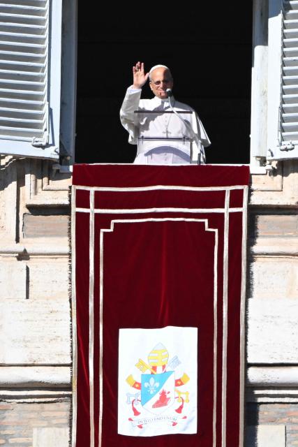Pope Leo XIV waves to the crowd from the window of the apostolic palace overlooking St. Peter's square during the Angelus prayer in The Vatican on December 28, 2025. (Photo by Andreas SOLARO / AFP)