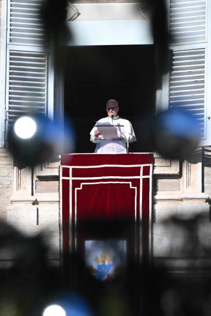 Pope Leo XIV delivers his speech to the crowd from the window of the apostolic palace overlooking St. Peter's square during the Angelus prayer in The Vatican on December 28, 2025. (Photo by Andreas SOLARO / AFP)