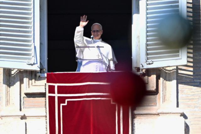 Pope Leo XIV waves to the crowd from the window of the apostolic palace overlooking St. Peter's square during the Angelus prayer in The Vatican on December 28, 2025. (Photo by Andreas SOLARO / AFP)
