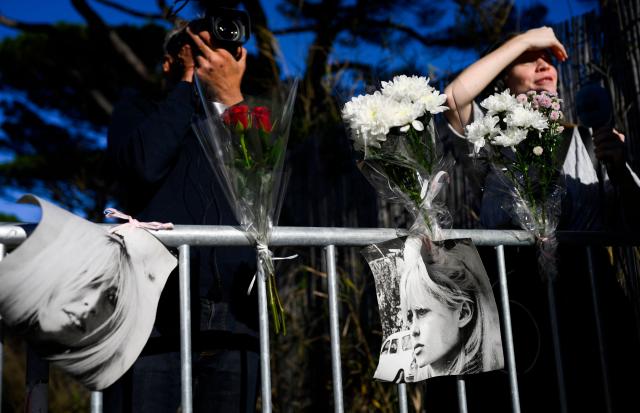 Portrais of late French actress Brigitte Bardot and flowers are displayed on barriers at the entrance of "La Madrague" house, property of late Brigitte Bardot in Saint-Tropez, southeastern France on December 28, 2025. French film legend Brigitte Bardot died at 91 AFP learnt from Bardot foundation on December 28, 2025. (Photo by Frederic DIDES / AFP)