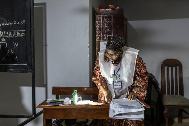 An official of the General Directorate of Elections (DGE) checks a voters' roll at a polling station in Conakry on December 28, 2025 during Guinea's presidential election. (Photo by PATRICK MEINHARDT / AFP)